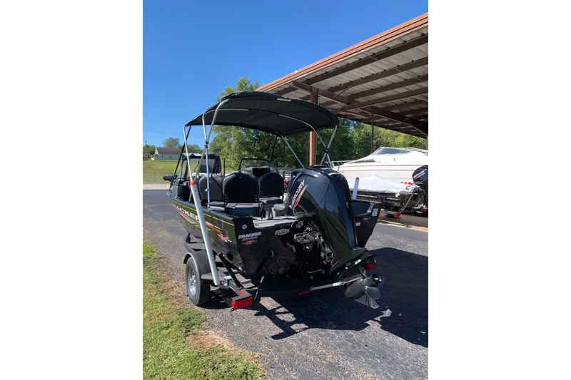Slide: The Image of 2023 Bass Tracker Pro Guide V-16 WT boat with Mercury engine, parked outdoors. - 3