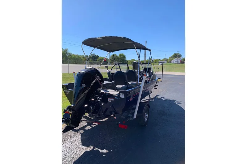 Slide: The Image of 2023 Bass Tracker Pro Guide V-16 WT boat with canopy and outboard motor. - 4