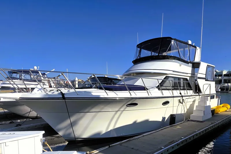 The Image of 1990 Californian 48 Cockpit Motor Yacht docked at marina under clear blue sky. - 0