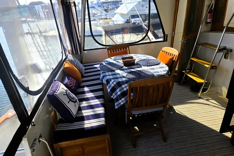 Slide: The Image of Interior of 1990 Californian 48 Cockpit Motor Yacht with dining area and nautical decor. - 1