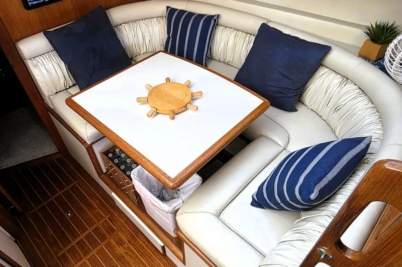 Slide: The Image of 1990 Californian 48 Cockpit Motor Yacht interior with white seating and blue cushions. - 16