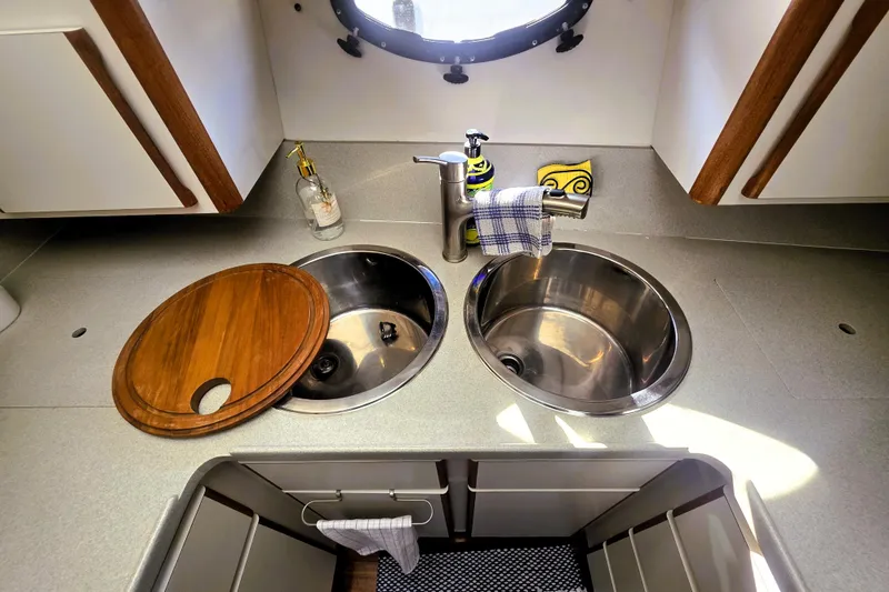 Slide: The Image of 1990 Californian 48 Cockpit Motor Yacht kitchen sink area with dual basins and wooden cover. - 21