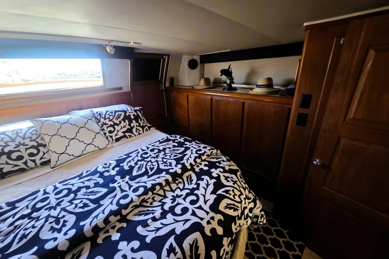 Slide: The Image of Luxurious bedroom in 1990 Californian 48 Cockpit Motor Yacht with elegant bedding and wooden cabinetry. - 32