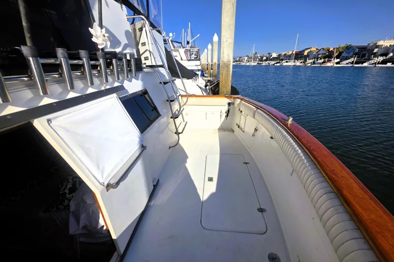 Slide: The Image of 1990 Californian 48 Cockpit Motor Yacht docked, showcasing spacious deck and serene waterfront view. - 37