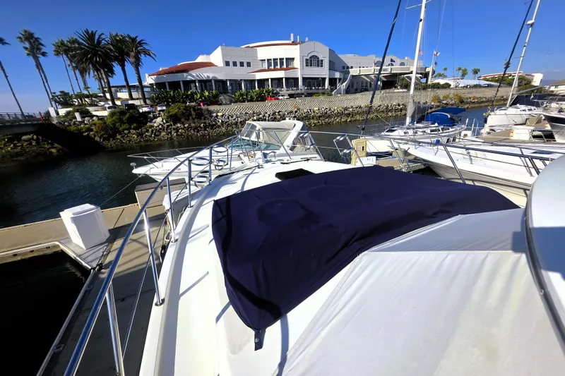 Slide: The Image of 1990 Californian 48 Cockpit Motor Yacht docked at marina with palm trees and building. - 41