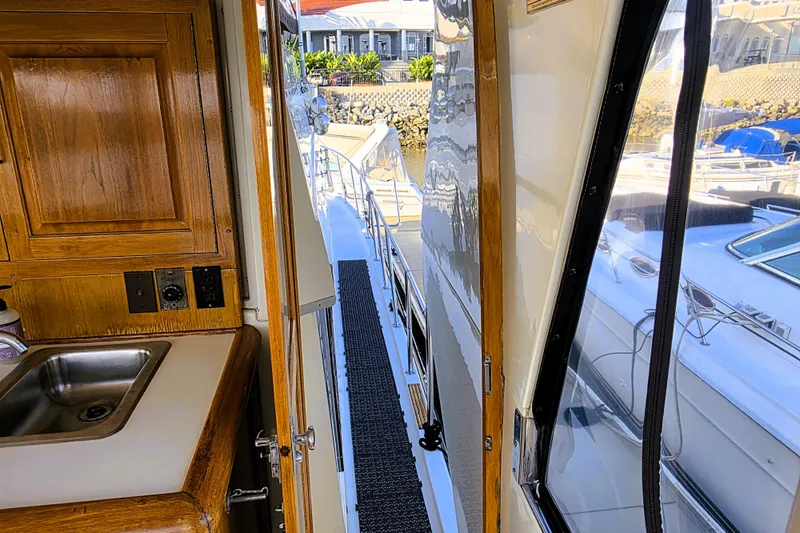 Slide: The Image of 1990 Californian 48 Cockpit Motor Yacht interior view with sink and exterior walkway. - 56