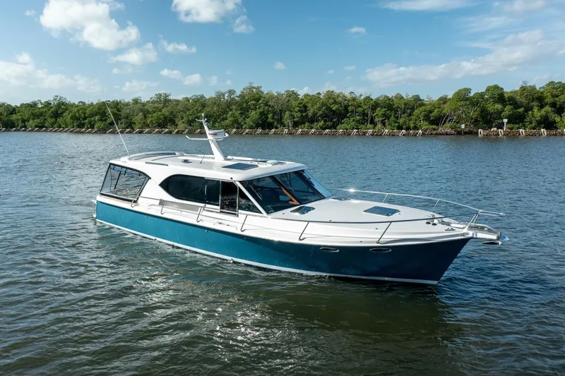 The Image of 2026 Hylas M49 yacht cruising on a serene river under a clear blue sky. - 1