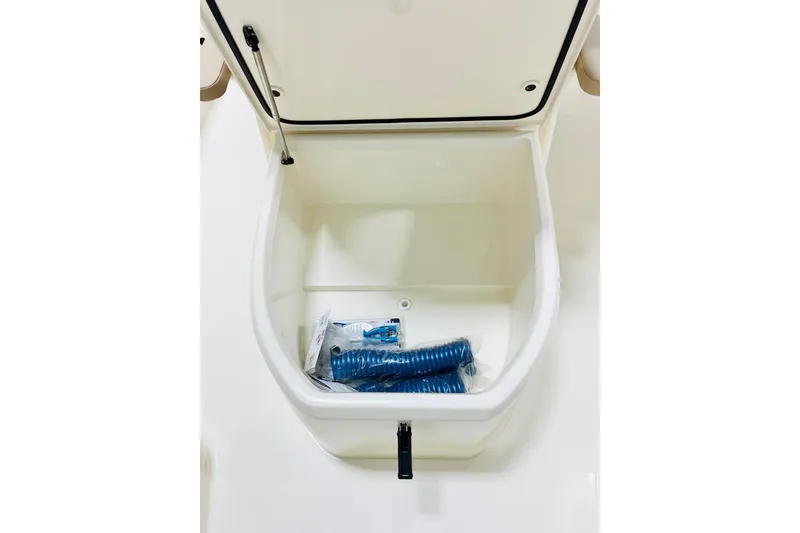 Slide: The Image of Storage compartment of 2026 Scout 231 XSB boat with blue hose inside. - 12