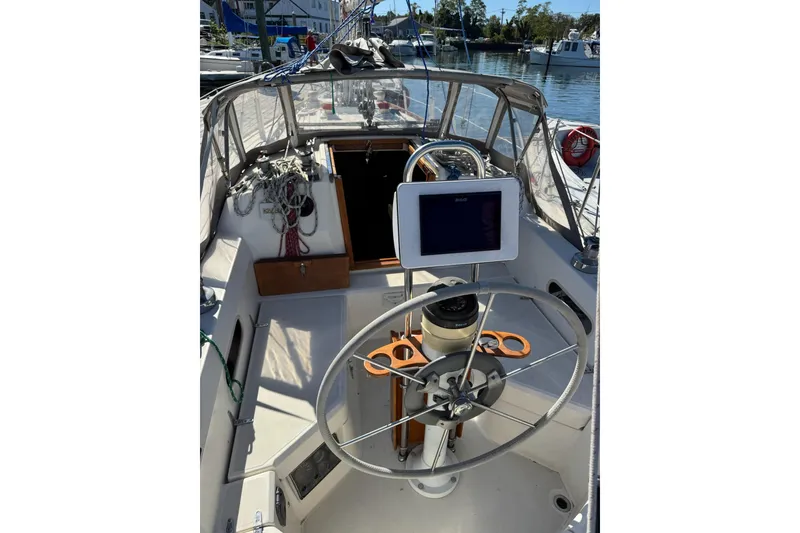 Slide: The Image of 1989 Sabre 30 MKIII sailboat cockpit with steering wheel and navigation equipment. - 12