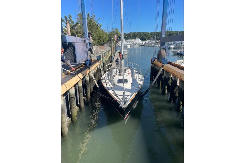 Slide: The Image of 1989 Sabre 30 MKIII sailboat docked at a marina, surrounded by calm water. - 17