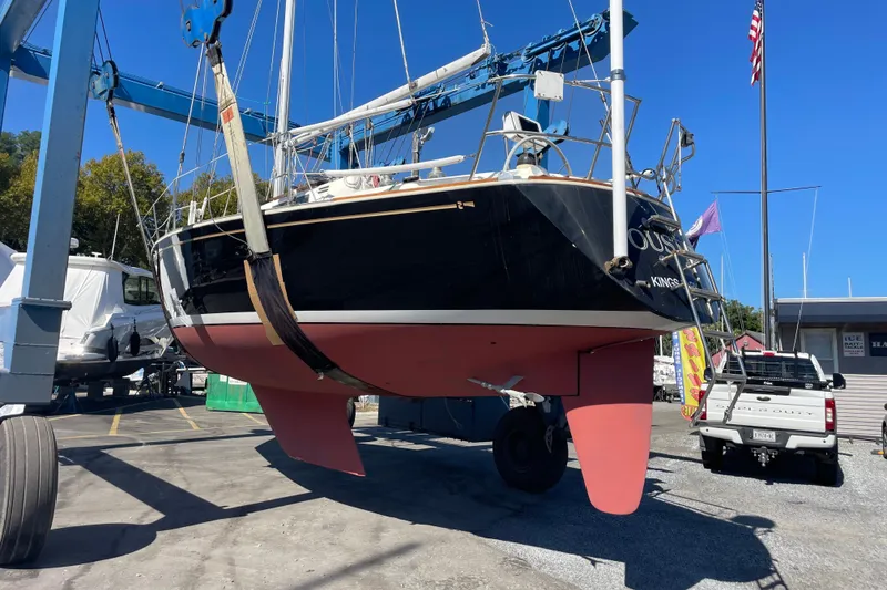 Slide: The Image of 1989 Sabre 30 MKIII sailboat in dry dock, with red hull and blue sky background. - 18