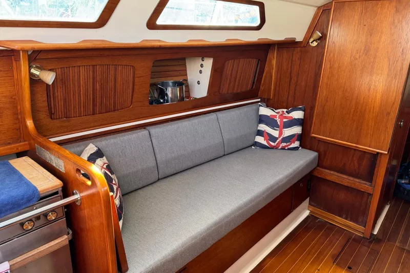 Slide: The Image of 1989 Sabre 30 MKIII yacht interior with wooden finish and gray cushioned seating. - 28