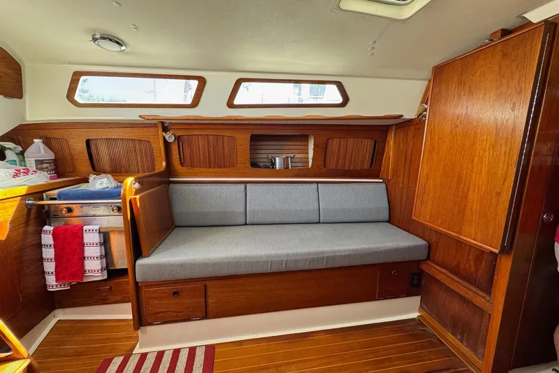 Slide: The Image of 1989 Sabre 30 MKIII yacht interior with wooden cabinetry and gray cushioned seating. - 30