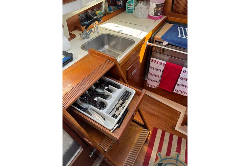 Slide: The Image of 1989 Sabre 30 MKIII yacht kitchen with sink, utensils, and wooden cabinetry. - 34
