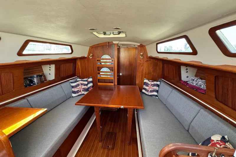 Slide: The Image of 1989 Sabre 30 MKIII sailboat interior with wooden table, gray seating, and nautical decor. - 38