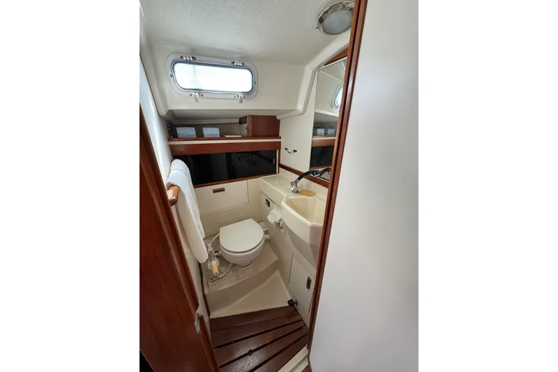 Slide: The Image of 1989 Sabre 30 MKIII yacht bathroom with sink, toilet, and porthole window. - 42