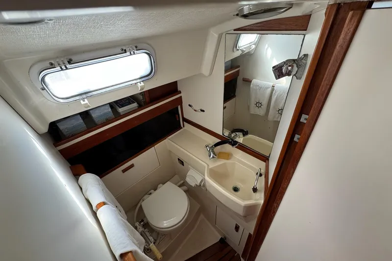 Slide: The Image of 1989 Sabre 30 MKIII yacht bathroom with sink, toilet, mirror, and nautical-themed decor. - 43