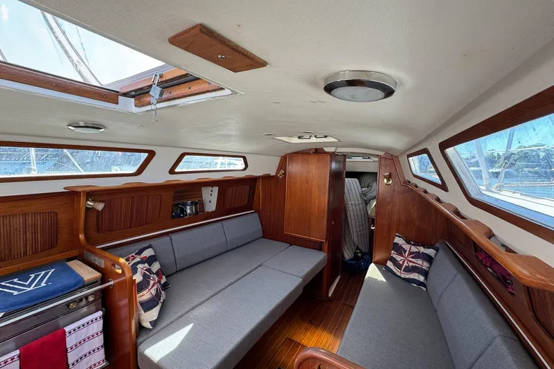 Slide: The Image of 1989 Sabre 30 MKIII yacht interior with wooden finish, skylight, and gray seating. - 49