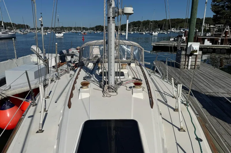 Slide: The Image of 1989 Sabre 30 MKIII sailboat docked at a marina, surrounded by calm waters and other boats. - 7