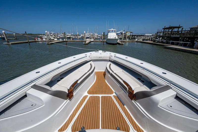 Slide: The Image of Yellowfin 54 Offshore 2022 boat docked at marina, featuring spacious deck and seating. - 22