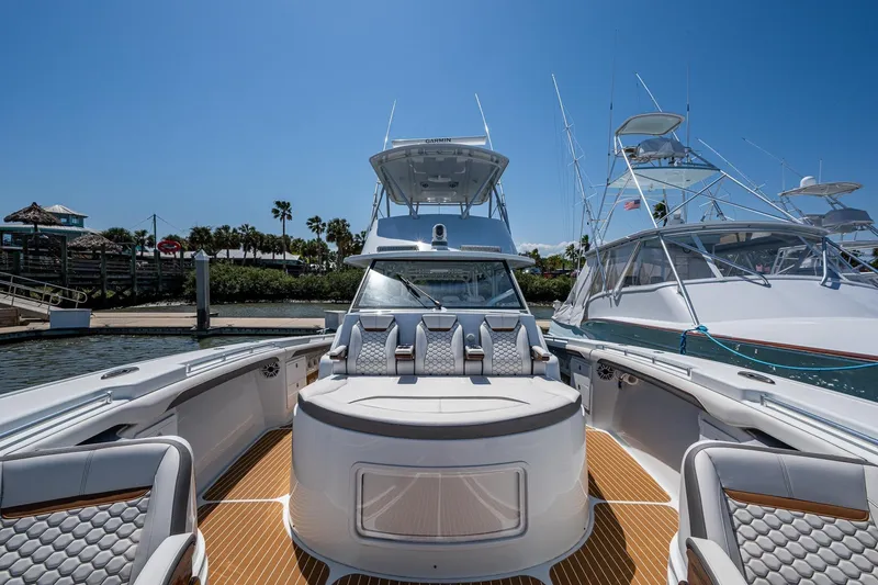 Slide: The Image of 2022 Yellowfin 54 Offshore boat docked, showcasing luxurious seating and sleek design. - 32