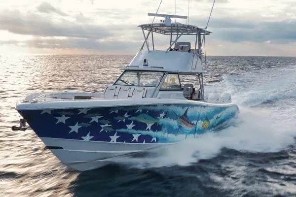 Slide: The Image of 2022 Yellowfin 54 Offshore boat with vibrant marine-themed hull design cruising on open water. - 4