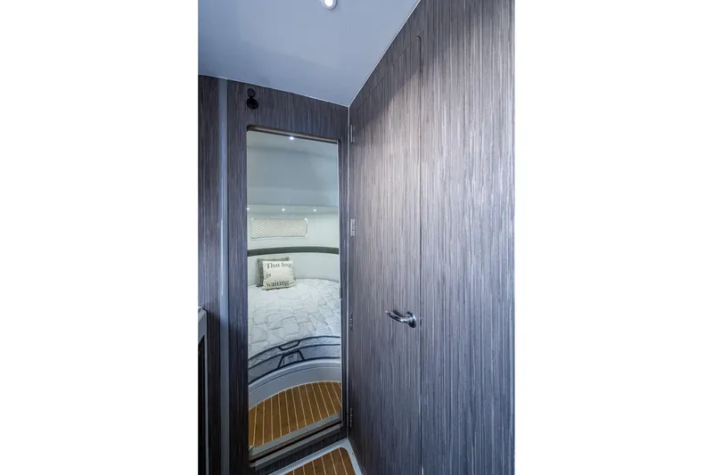 Slide: The Image of 2022 Yellowfin 54 Offshore cabin interior with modern wood paneling and cozy bedding. - 44