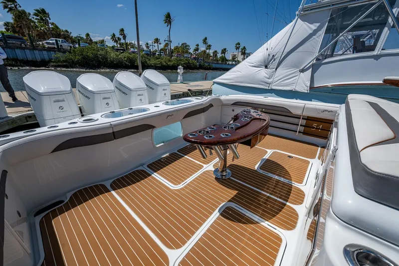 Slide: The Image of 2022 Yellowfin 54 Offshore boat deck with seating, table, and multiple outboard engines. - 46