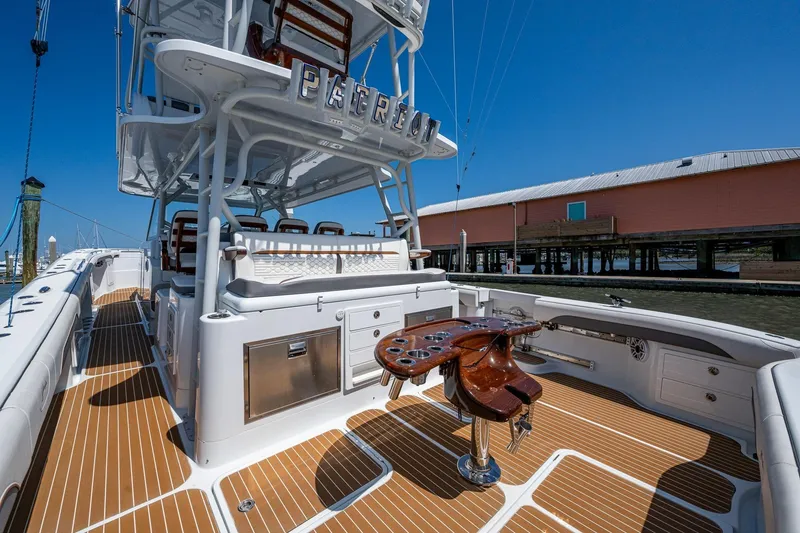 Slide: The Image of 2022 Yellowfin 54 Offshore boat with teak deck and fishing setup, docked under clear blue sky. - 48