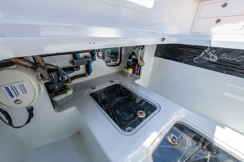 Slide: The Image of 2022 Yellowfin 54 Offshore boat interior with visible wiring and storage compartments. - 56