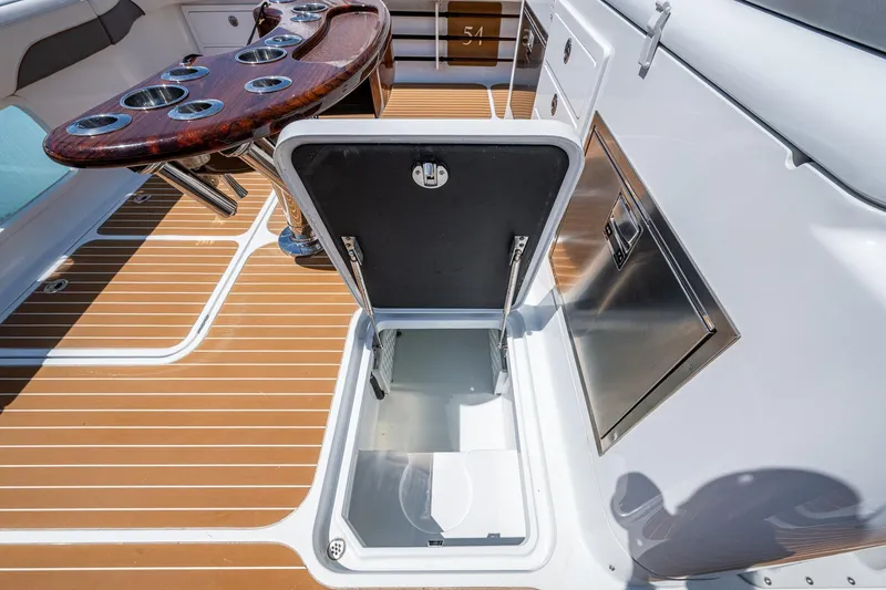 Slide: The Image of 2022 Yellowfin 54 Offshore boat deck with open storage compartment and rod holders. - 58