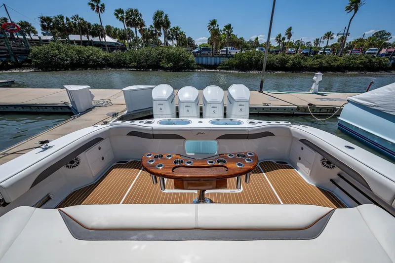 Slide: The Image of 2022 Yellowfin 54 Offshore boat interior with seating, table, and outboard motors at dock. - 59