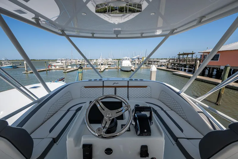Slide: The Image of 2022 Yellowfin 54 Offshore boat helm with marina view, showcasing luxury design and advanced controls. - 73