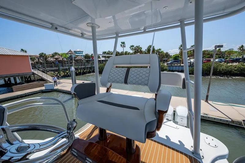 Slide: The Image of 2022 Yellowfin 54 Offshore boat helm seat with luxurious design at marina dock. - 75