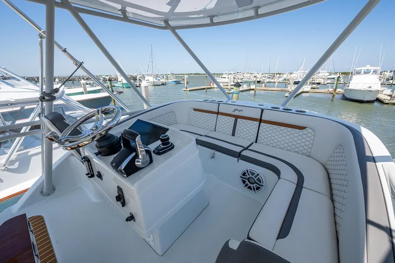 Slide: The Image of 2022 Yellowfin 54 Offshore boat helm with luxurious seating and marina view. - 76