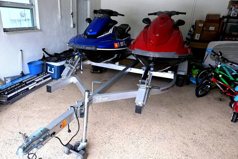 Slide: The Image of Two Yamaha WaveRunner EX Deluxe jet skis on a trailer in a garage. - 1