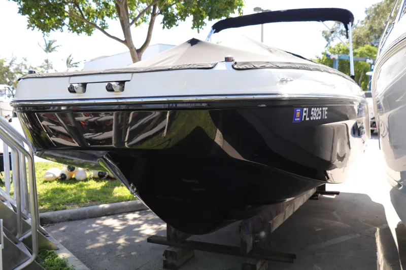 Slide: The Image of 2022 Bayliner DX 2200 boat on trailer, black hull, parked outdoors. - 1