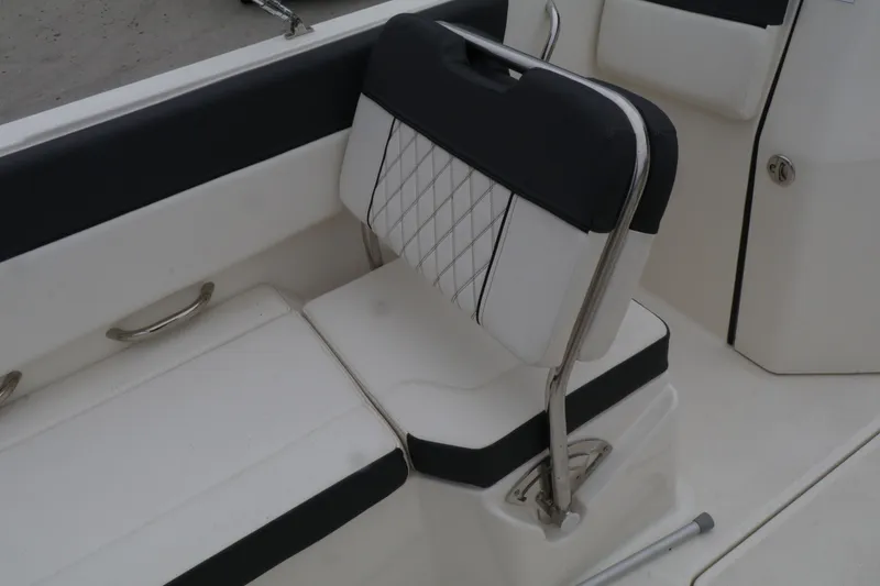 Slide: The Image of 2022 Bayliner DX 2200 boat interior with cushioned seating and stainless steel accents. - 10