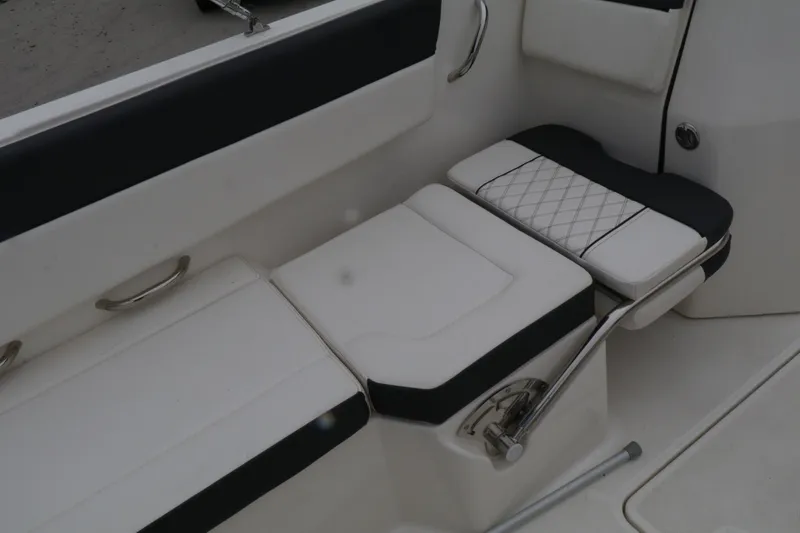 Slide: The Image of 2022 Bayliner DX 2200 boat interior seating with white and black upholstery. - 11