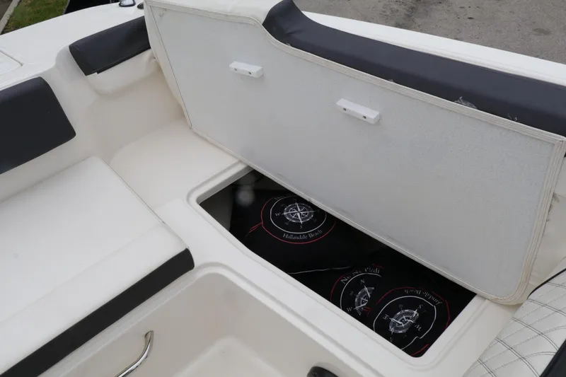 Slide: The Image of 2022 Bayliner DX 2200 boat storage compartment with open lid, revealing interior space. - 14