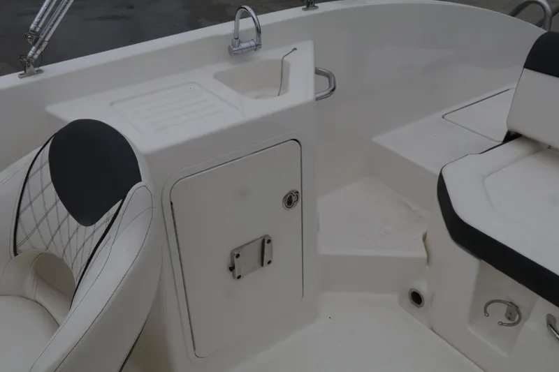 Slide: The Image of 2022 Bayliner DX 2200 boat interior with seating and storage compartment. - 16