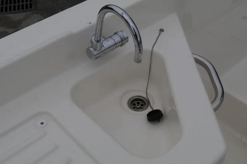 Slide: The Image of Bayliner DX 2200 2022 boat sink with chrome faucet and drain plug. - 17