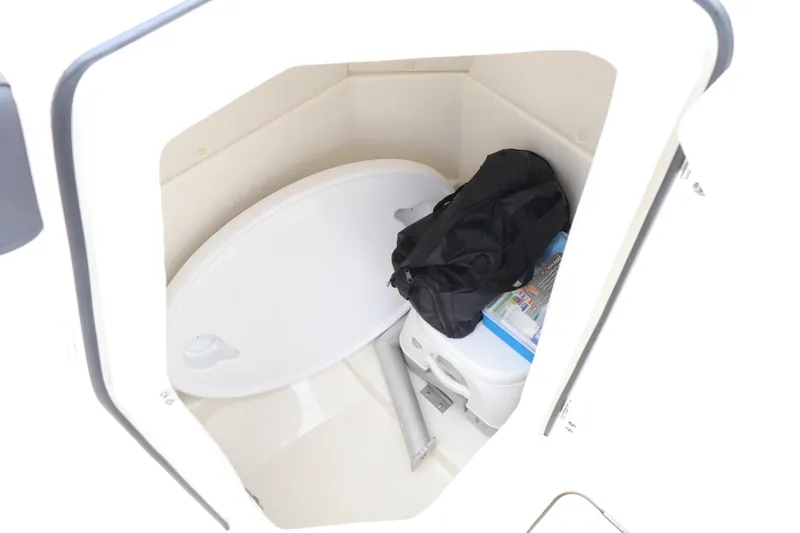 Slide: The Image of Storage compartment in 2022 Bayliner DX 2200 boat with portable toilet and gear. - 18