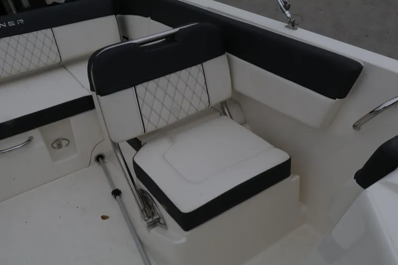 Slide: The Image of 2022 Bayliner DX 2200 boat interior seating with black and white upholstery. - 9