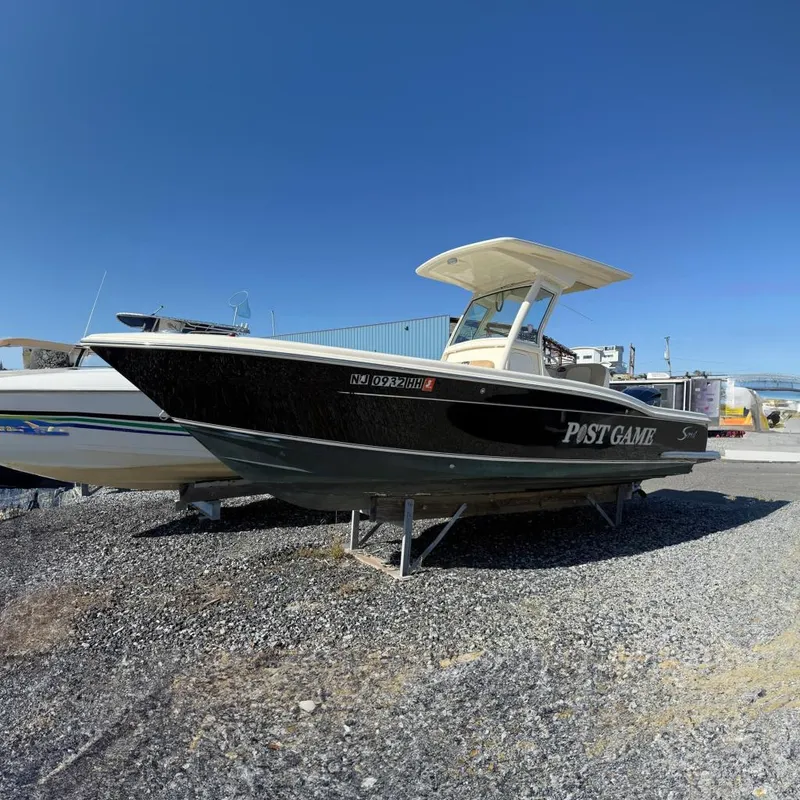 Slide: The Image of 2012 Scout 240 Bay Scout boat on gravel lot, side view. - 0