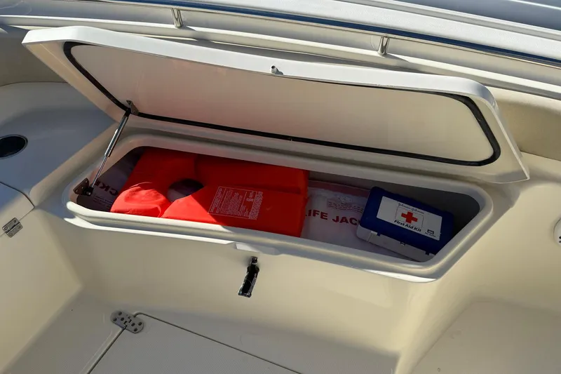 Slide: The Image of 2012 Scout 240 Bay Scout boat storage with life jacket and first aid kit. - 10