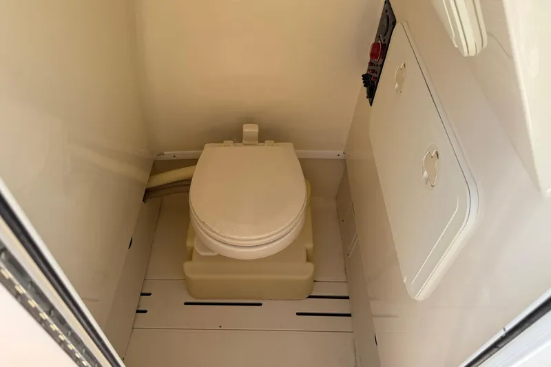 Slide: The Image of 2012 Scout 240 Bay Scout boat interior with compact marine toilet. - 12