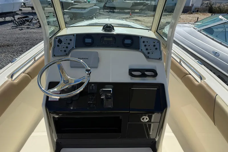 Slide: The Image of 2012 Scout 240 Bay Scout boat dashboard with steering wheel and Garmin navigation system. - 14