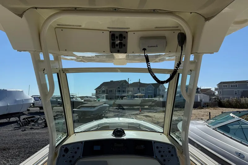 Slide: The Image of 2012 Scout 240 Bay Scout boat interior with Garmin equipment, docked near waterfront homes. - 15