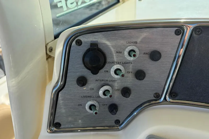 Slide: The Image of Control panel of a 2012 Scout 240 Bay Scout boat with various light switches. - 16